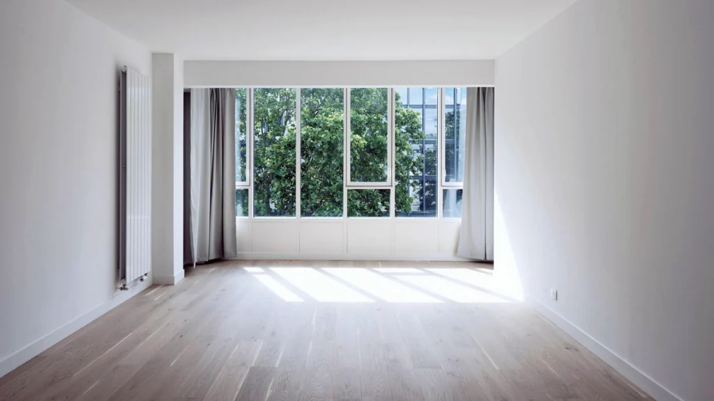 Bright empty apartment interior with large windows and natural daylight
