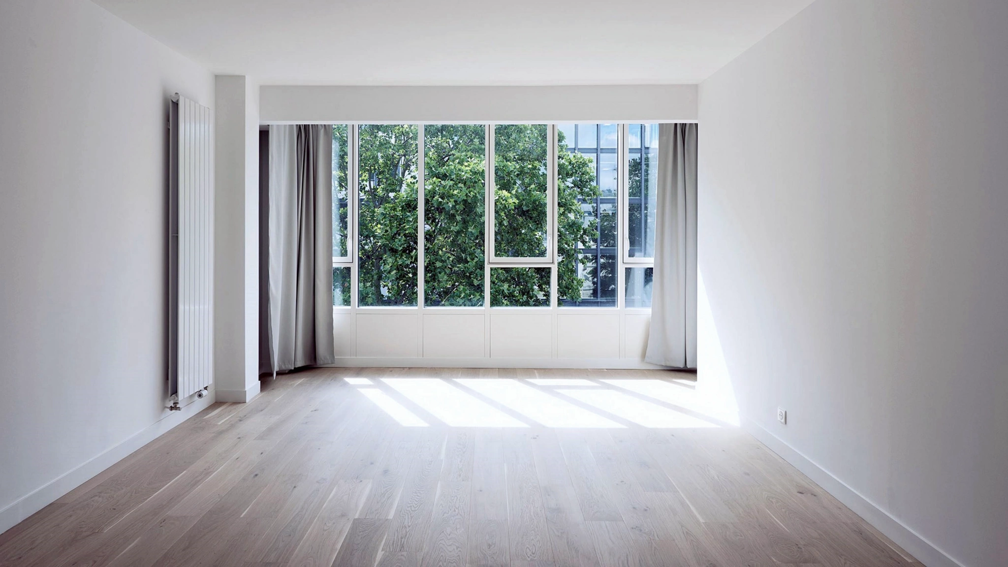 Bright empty apartment interior with large windows and natural daylight